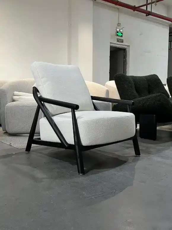 White fabric armchair with dark wood frame in factory