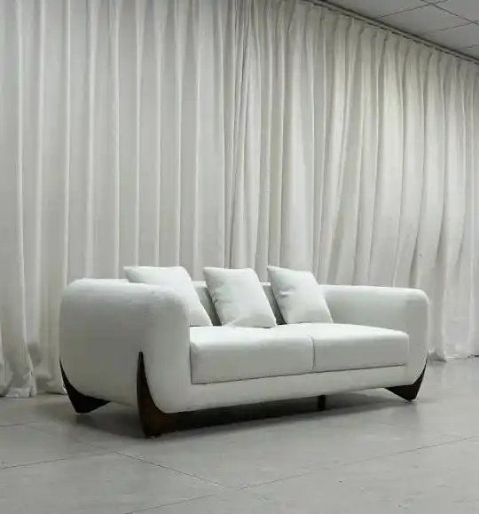 White upholstered sofa with wooden legs in workshop